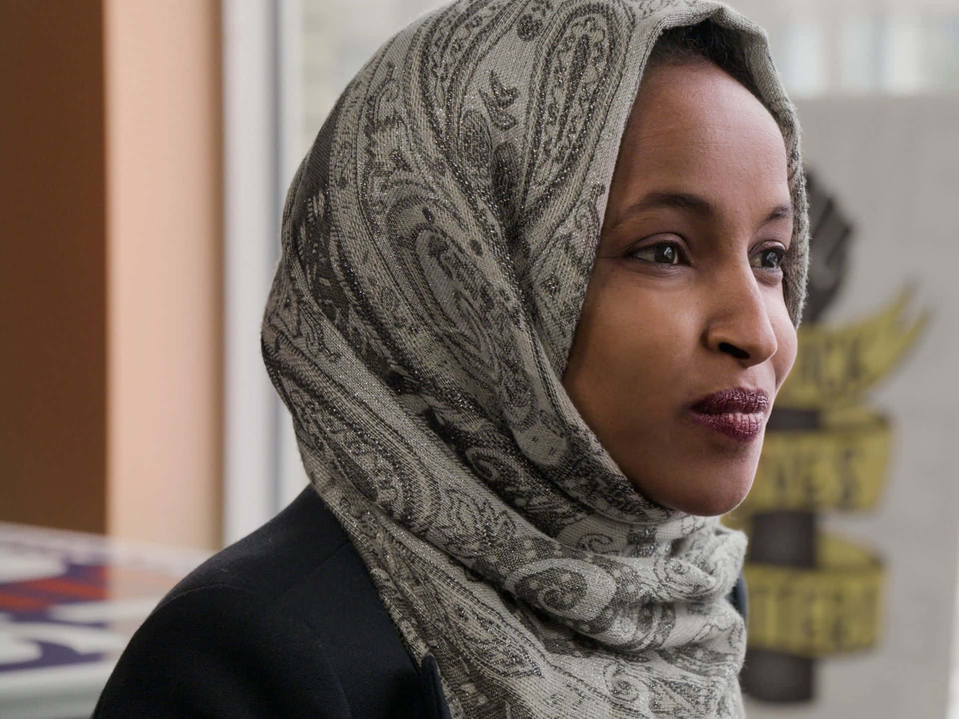 U.s. Representative Ilhan Omar With A Sparkling Gaze Background