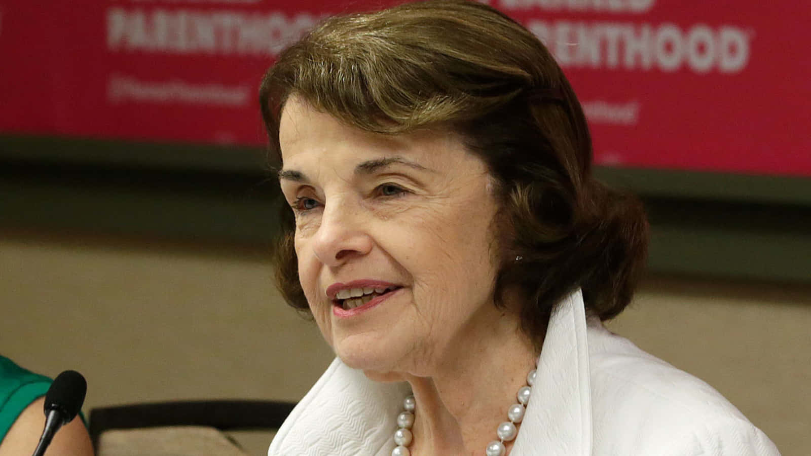 U.s. Senator Dianne Feinstein Wearing A Striking Pearl Necklace Background