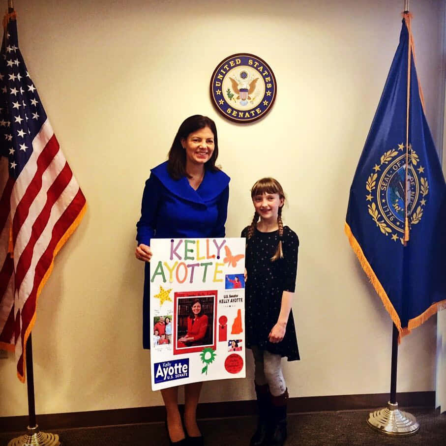 U.s. Senator Kelly Ayotte With A Little Girl Background