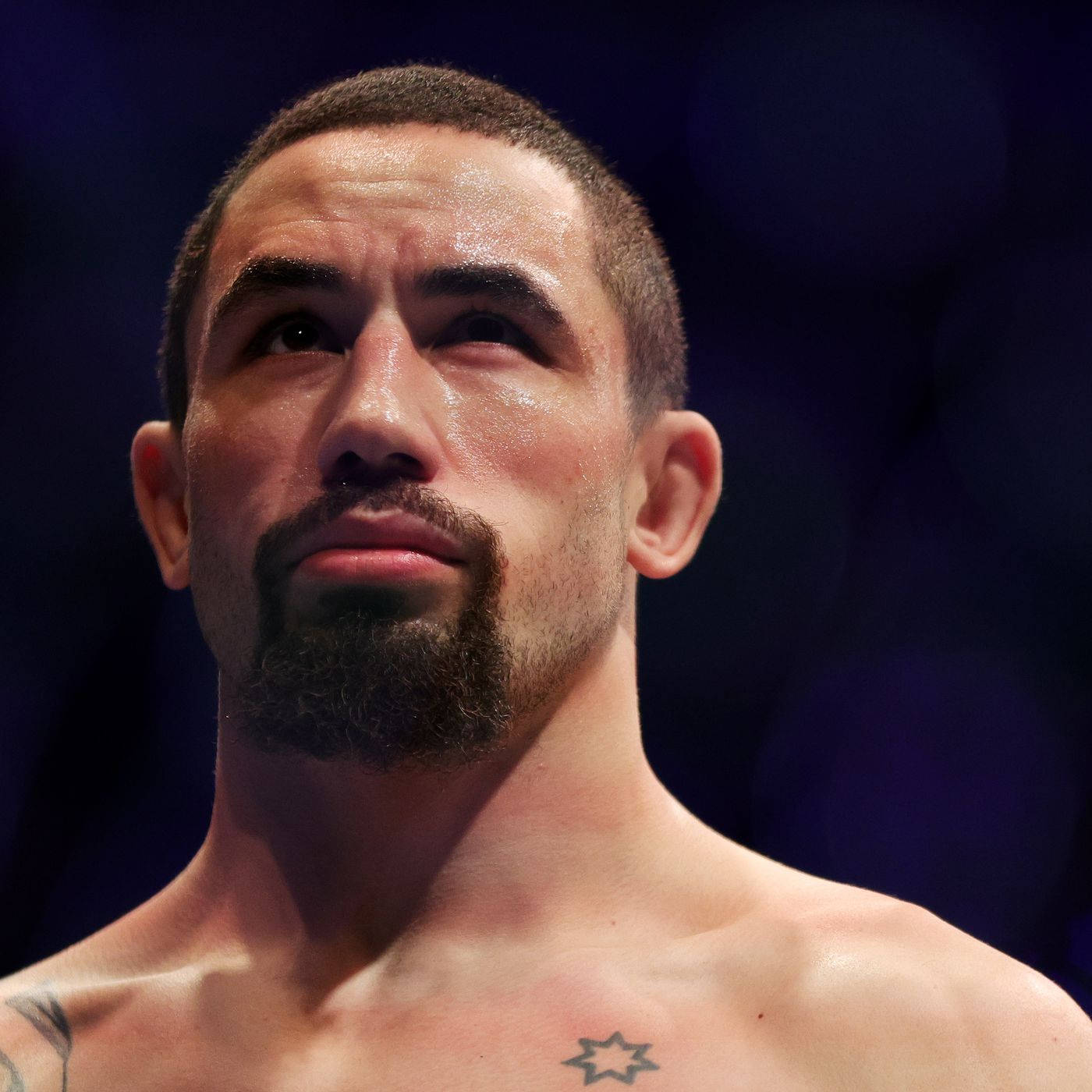 Ufc Fighter Robert Whittaker Posing Against A Black Backdrop Background