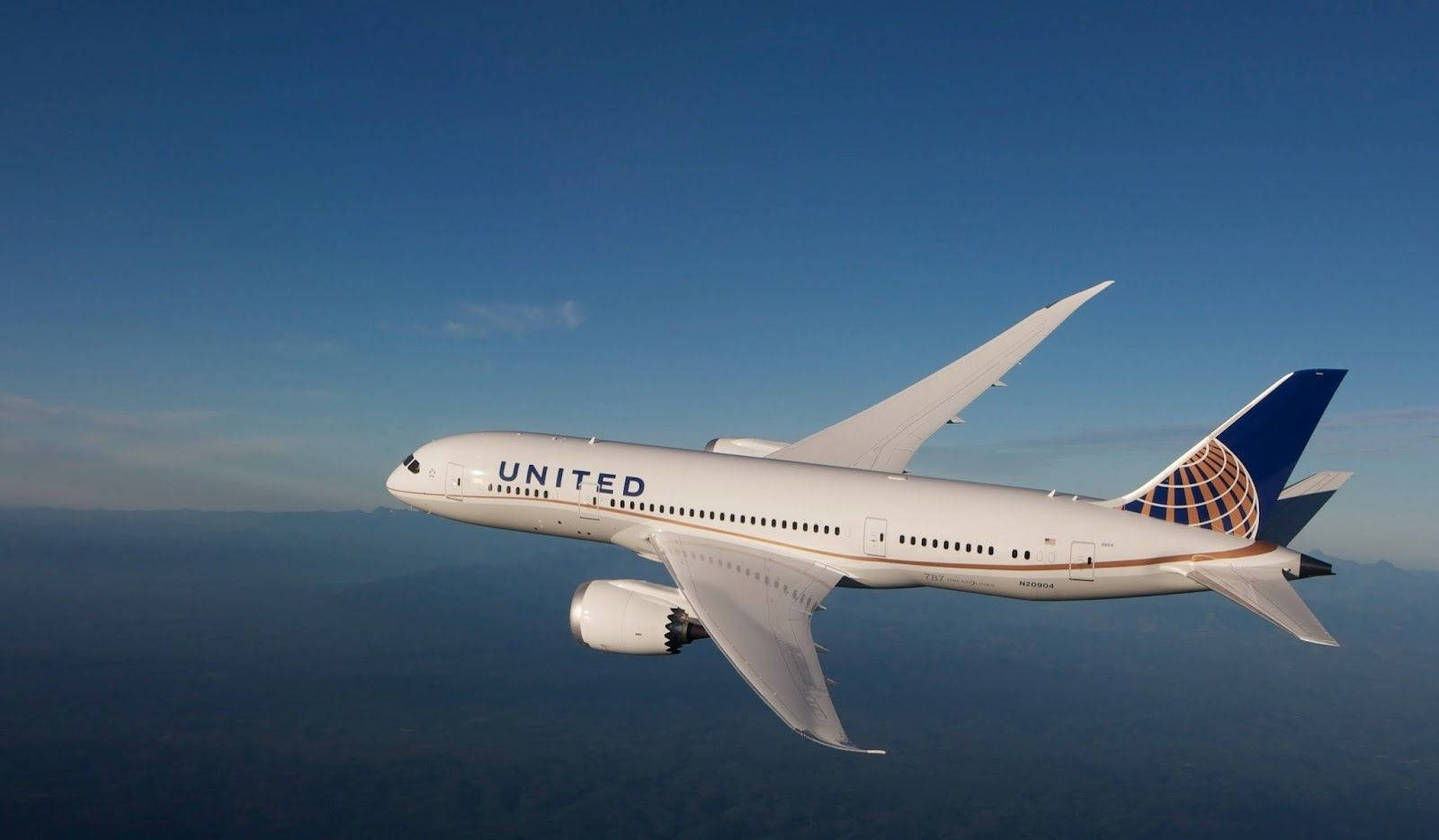 United Airplane Flying In Blue Sky Background