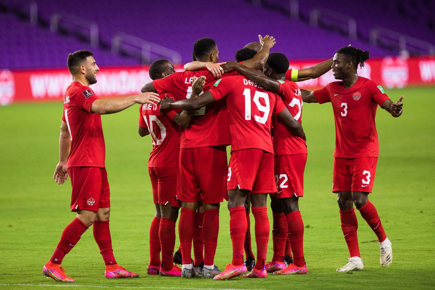 United We Stand - Canada National Football Team Embrace In Huddle Background