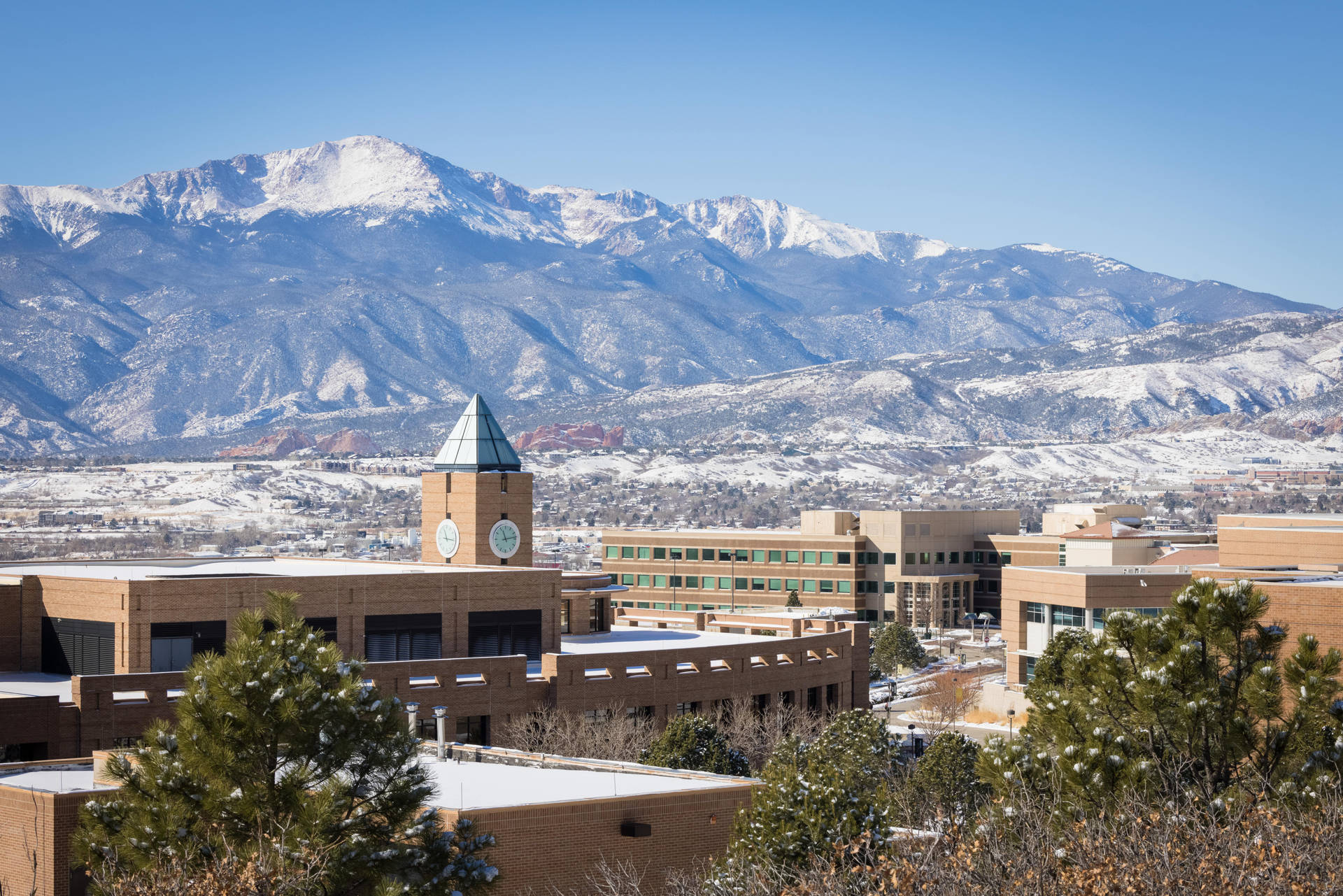 University Of Colorado Beautiful Campus Amid Snowy Mountains Background