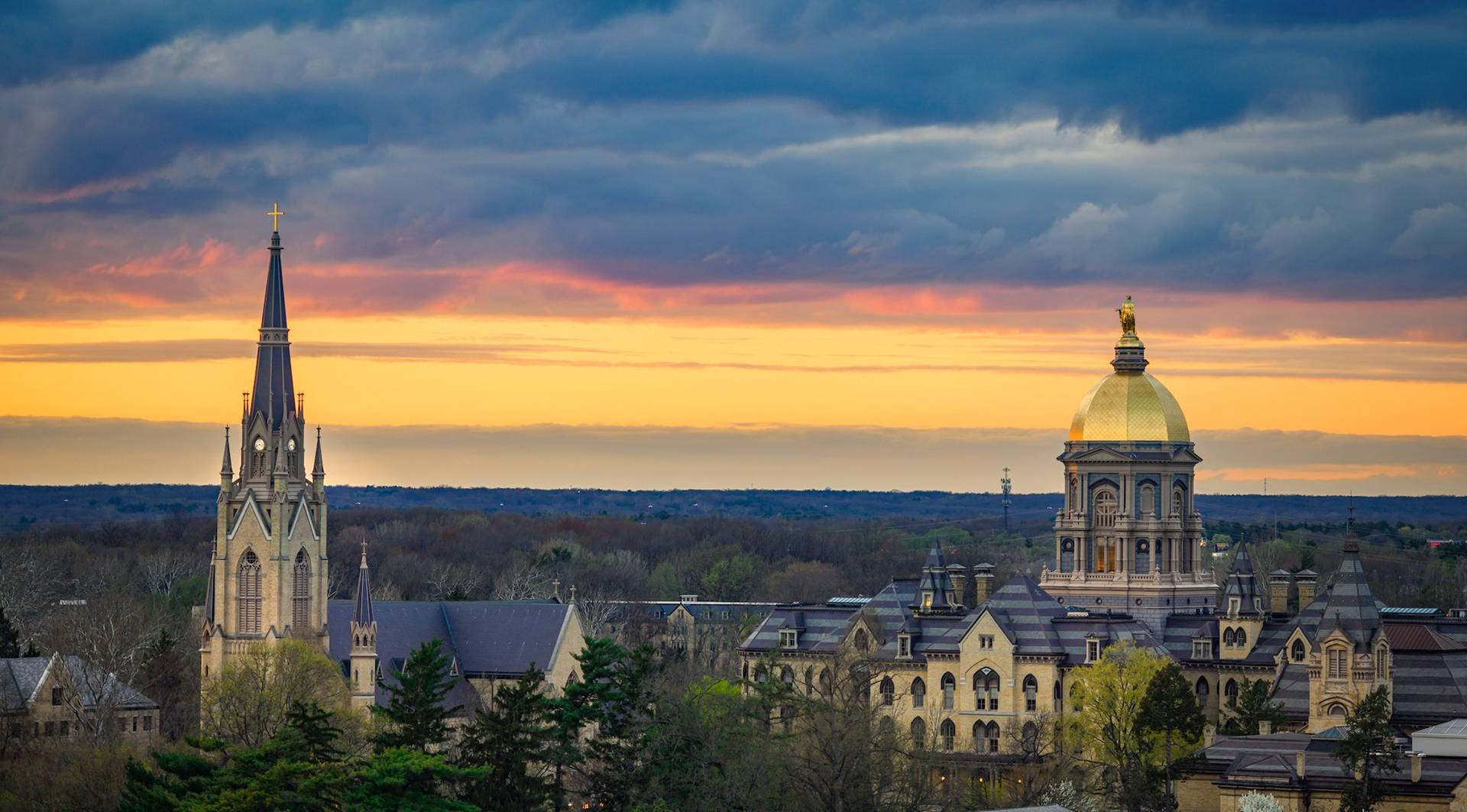 University Of Notre Dame Buildings Under Sunset Sky Background