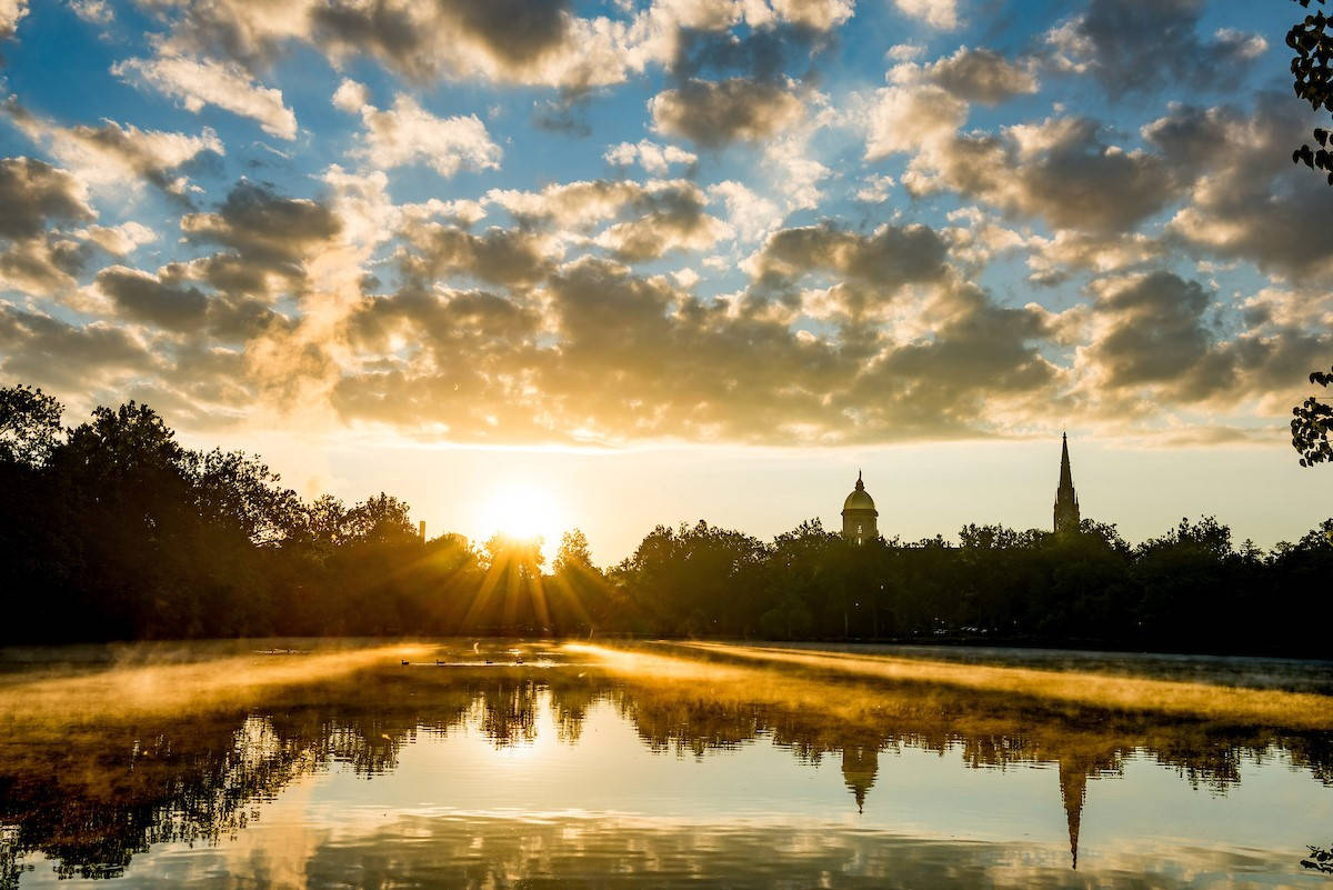 University Of Notre Dame Lake During Sunset Background