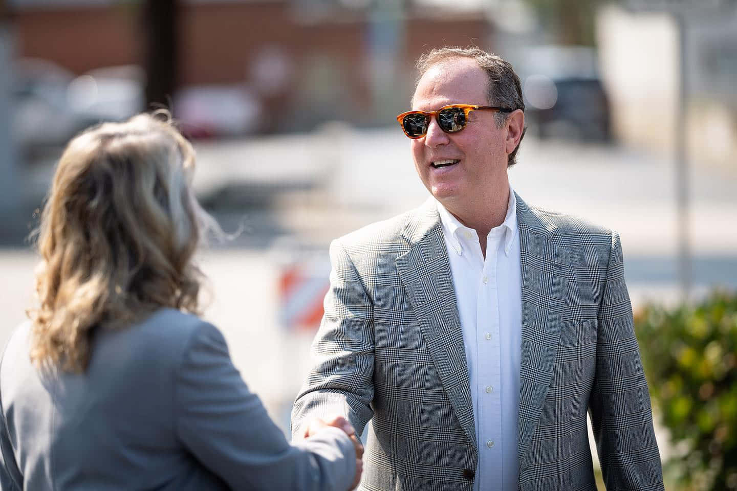Us Representative Adam Schiff Engaged In A Friendly Handshake Background
