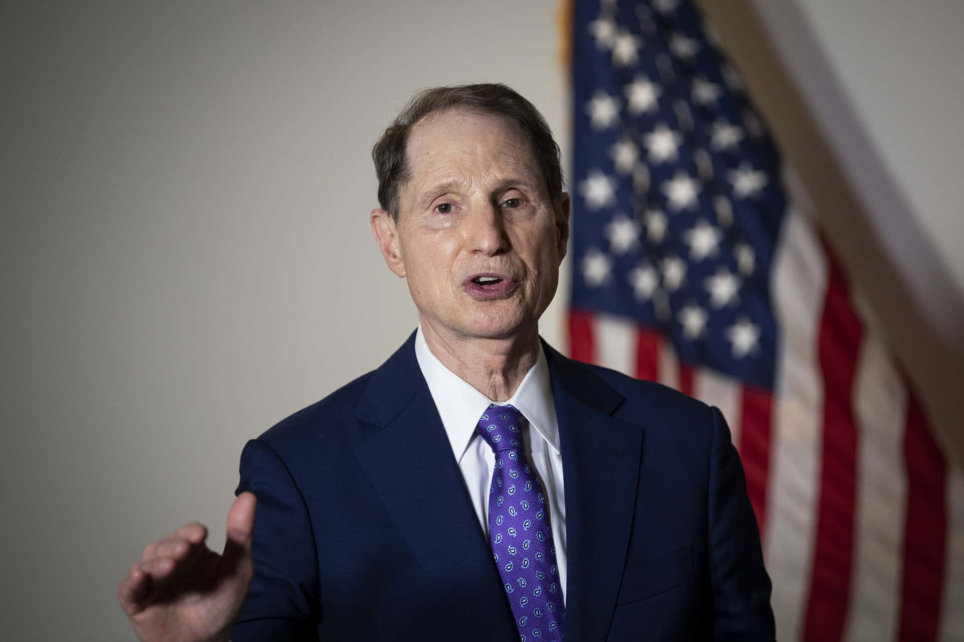 Us Senator Ron Wyden Standing Proud In Front Of The Us Flag Background