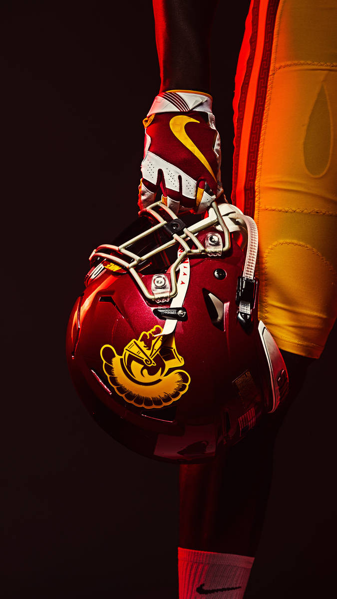 Usc Football Player Holding Helmet Background