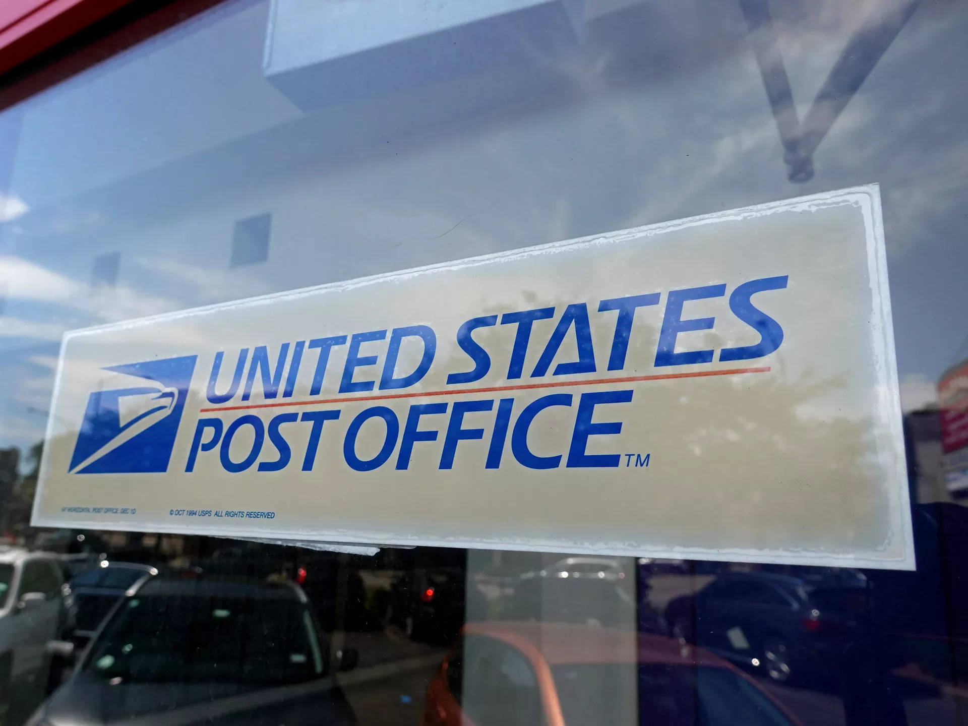 Usps Sign Behind Glass Background