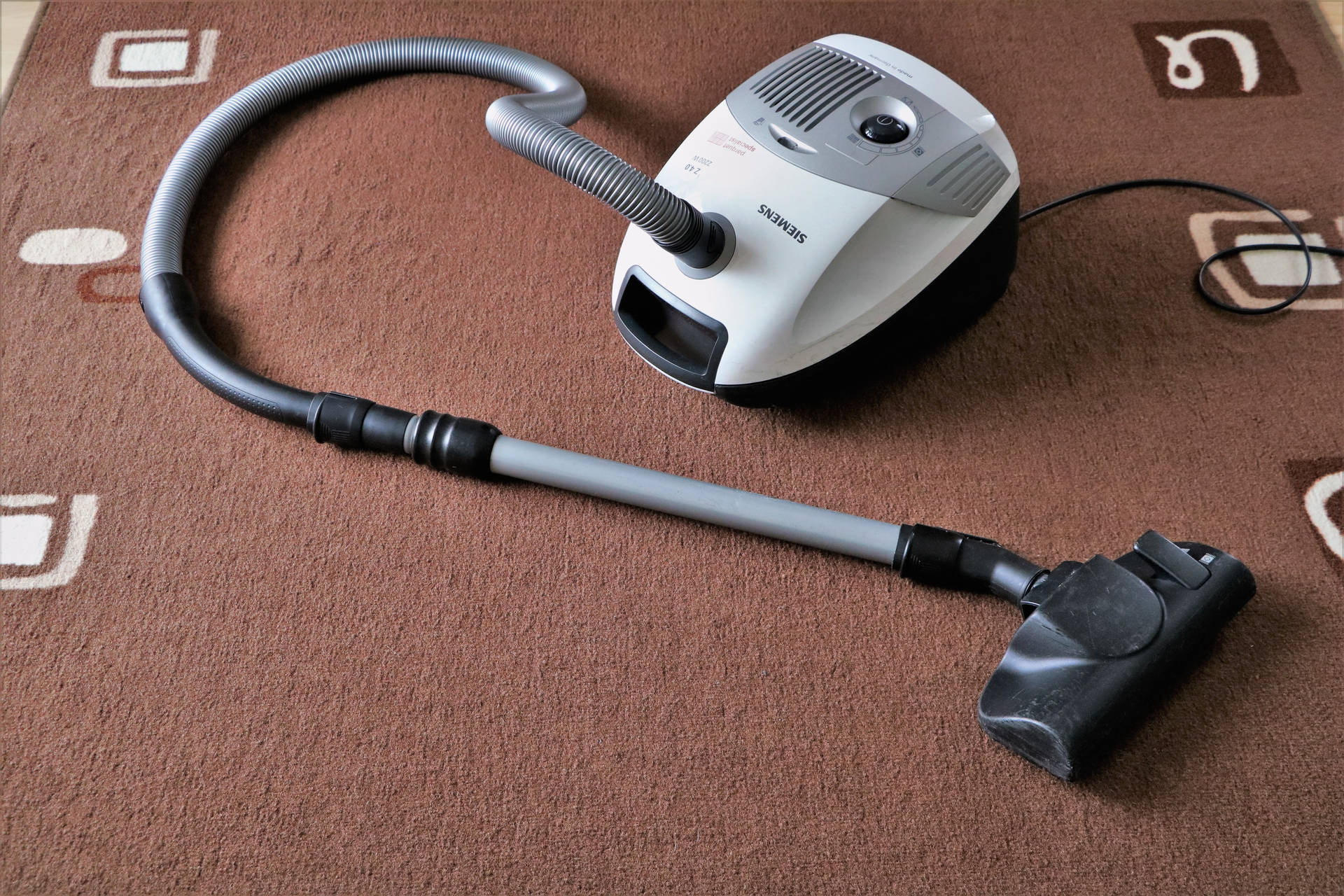 Vacuum Cleaner On Brown Rug Background