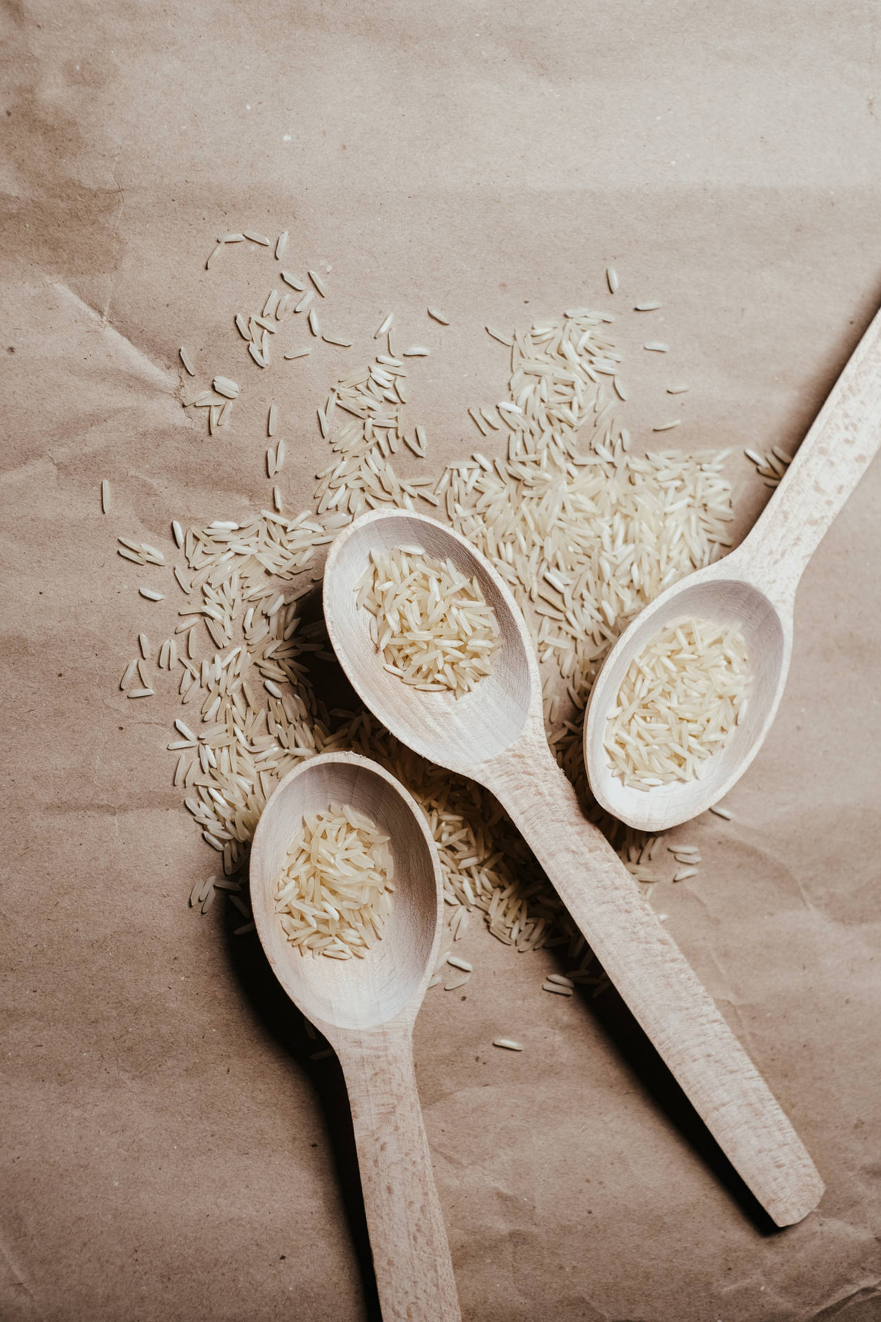 Variety Of Raw Rice On Three Spoons Background