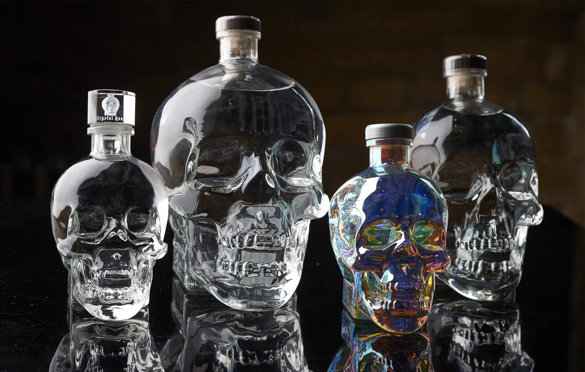 Varying Sizes Of Crystal Head Vodka Bottles Against An Elegant Backdrop Background