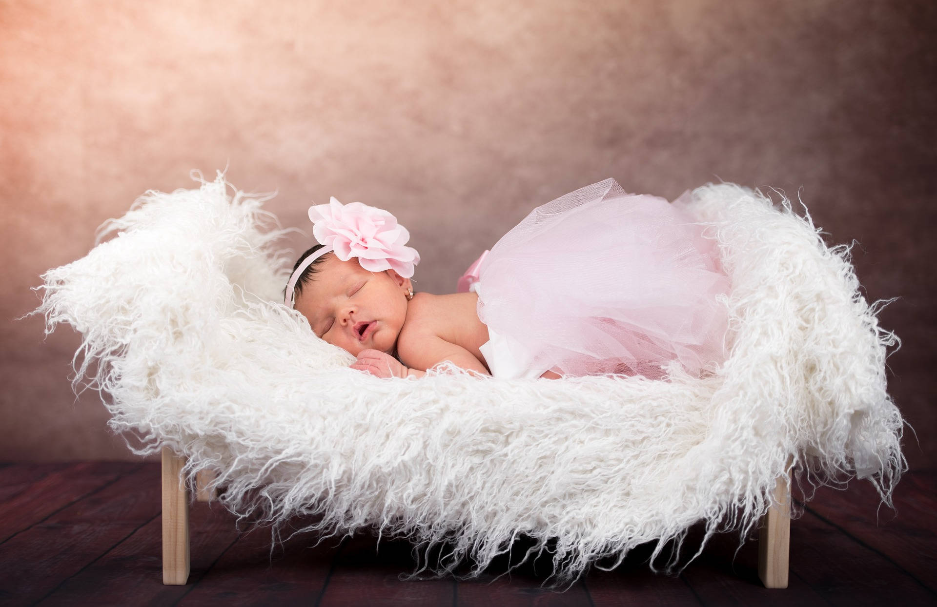 Very Cute Baby On Fluffy Bed Background