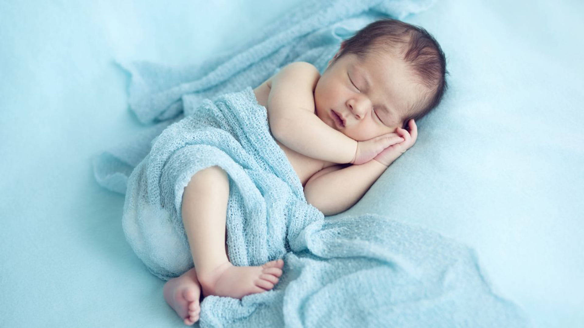Very Cute Baby With Blue Blanket Background