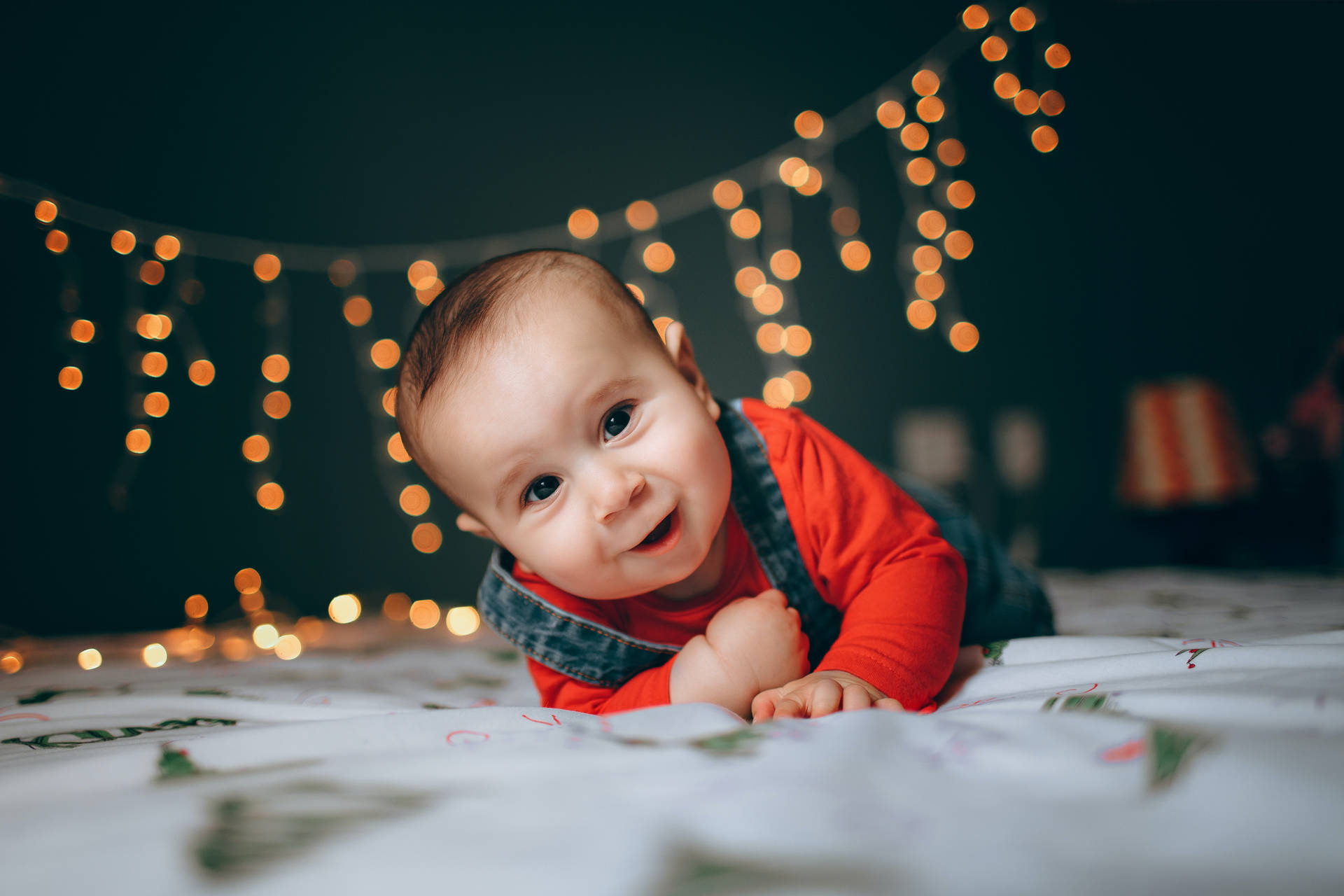 Very Cute Baby With Christmas Lights Background