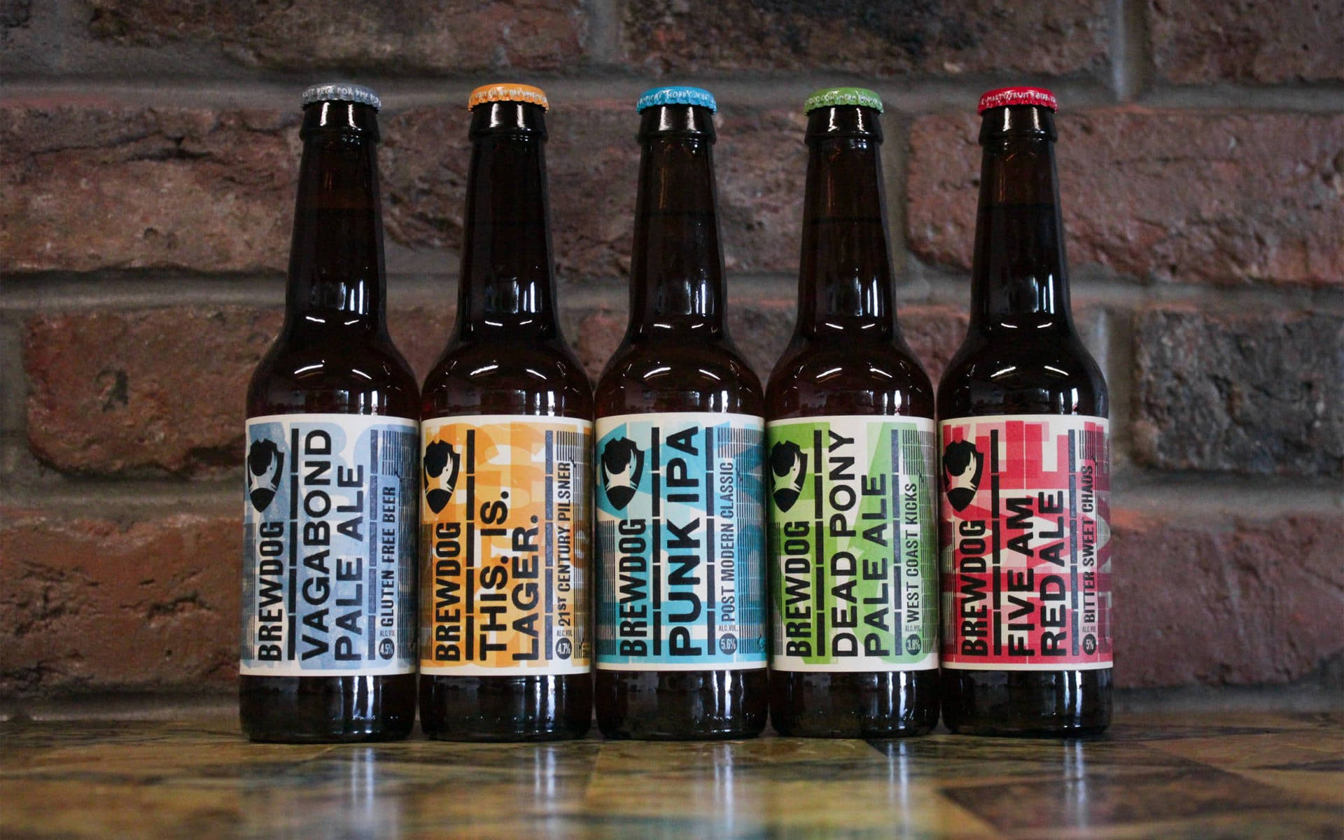 Vibrant Array Of Brewdog Craft Beer Bottles Against A Brick Wall Background