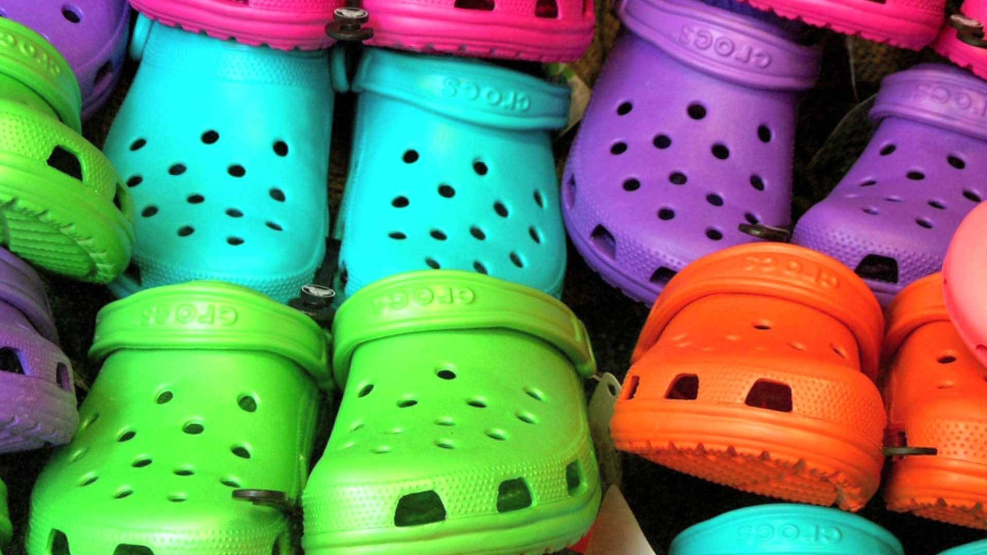 Vibrant Array Of Colorful Crocs Shoes Background