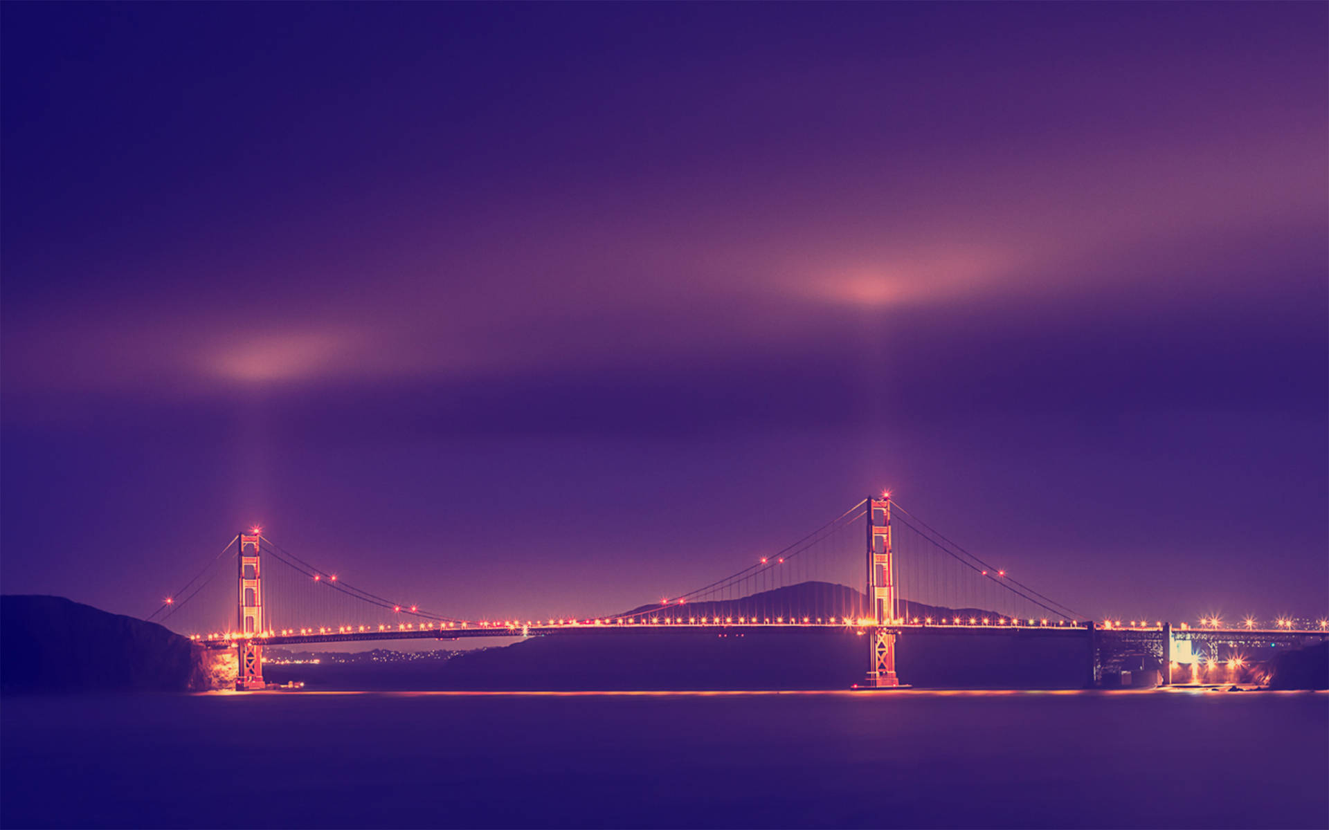 Vibrant Golden Gate Bridge Illuminated At Night Background