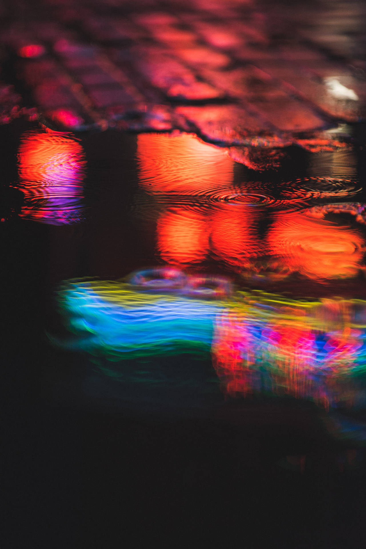 Vibrant Night Colors Reflecting On An Urban Puddle