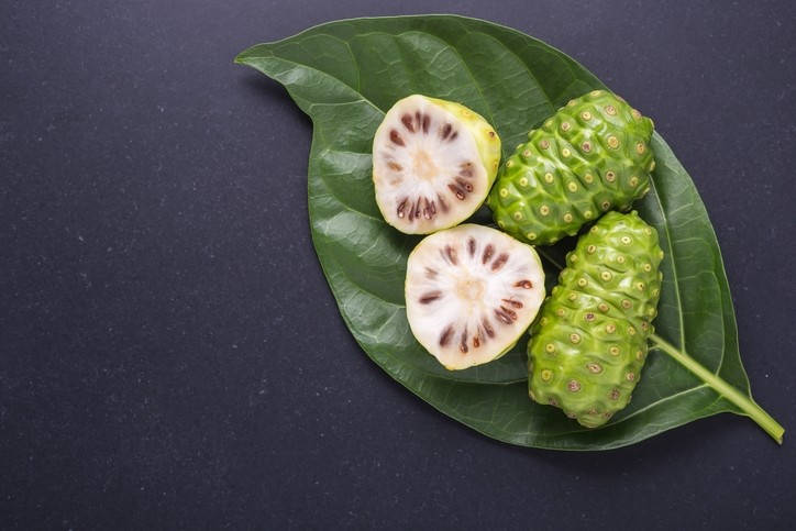 Vibrant Noni Fruits Nestled In Lush Green Foilage Background