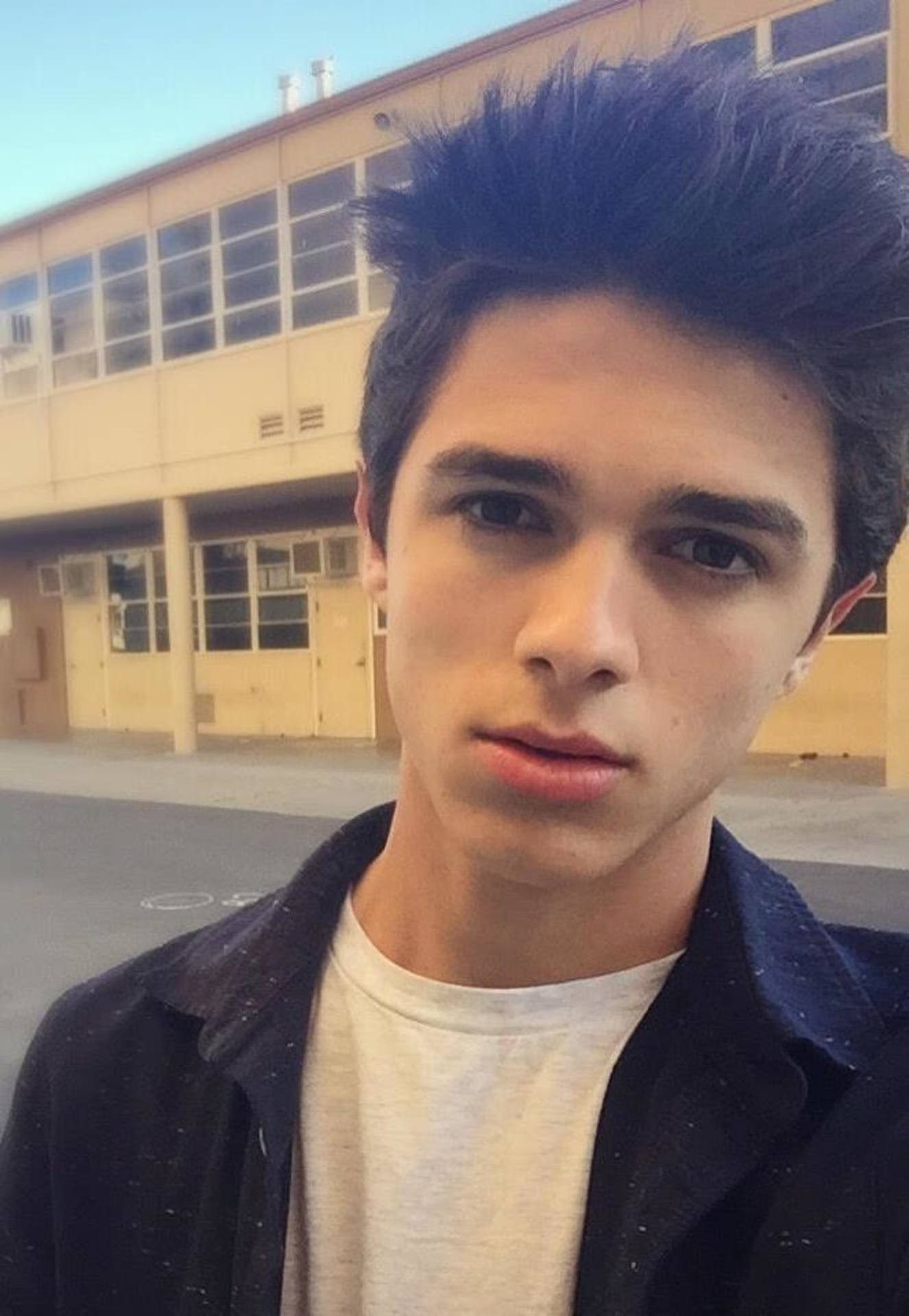 Vibrant Photo Of Brent Rivera Leaning Against A Building.