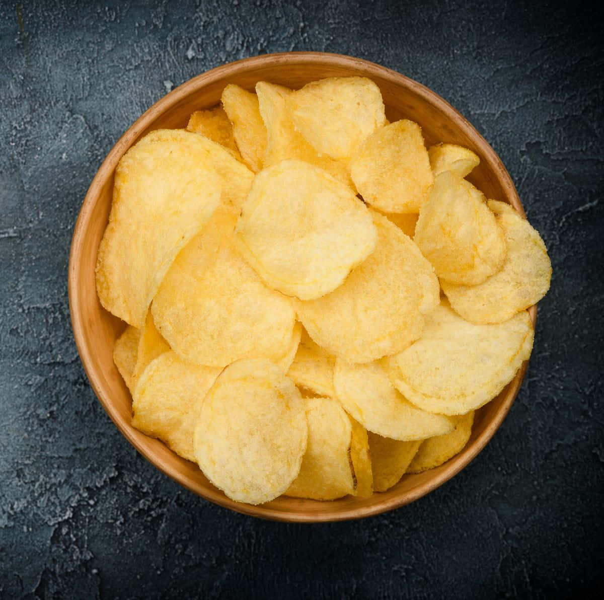 Vibrant Potato Chips Against A Black Background Background