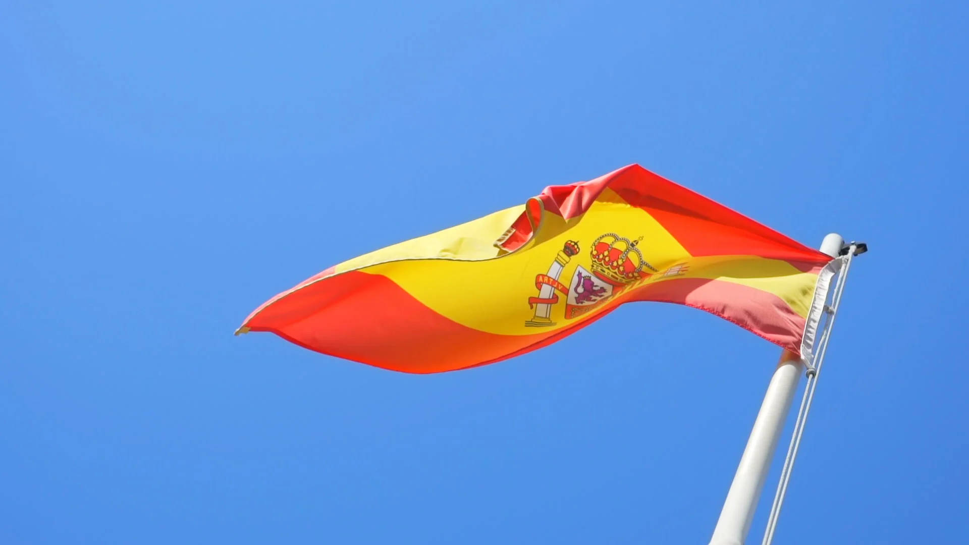 Vibrant Wavy Spain Flag On A Pole Background