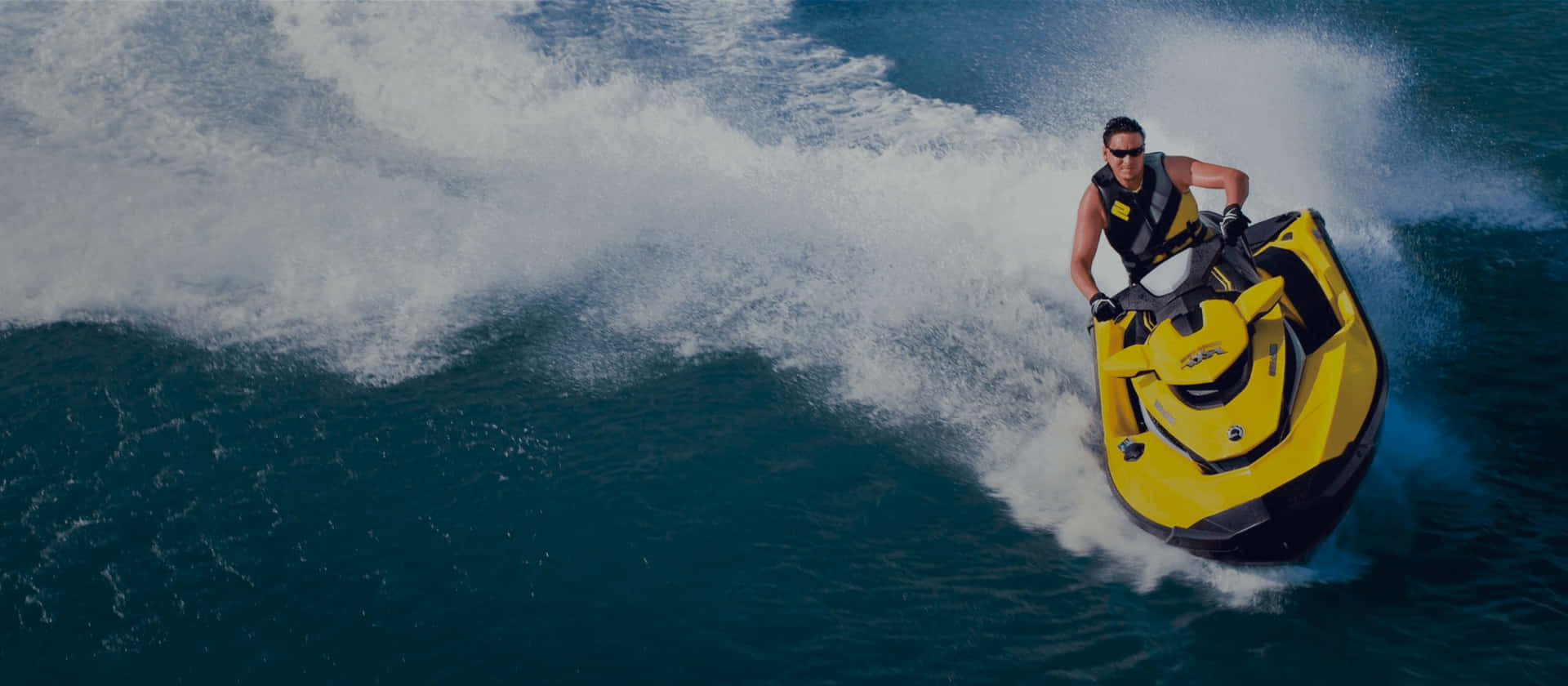 Vibrant Yellow Jet Ski Riding The Waves Background