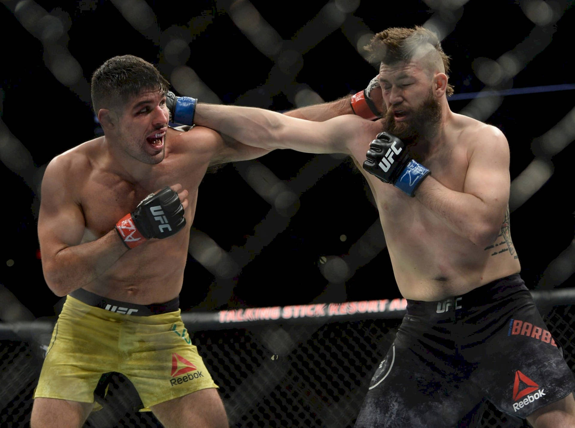 Vicente Luque Fiercely Battling It Out Inside The Octagon Background