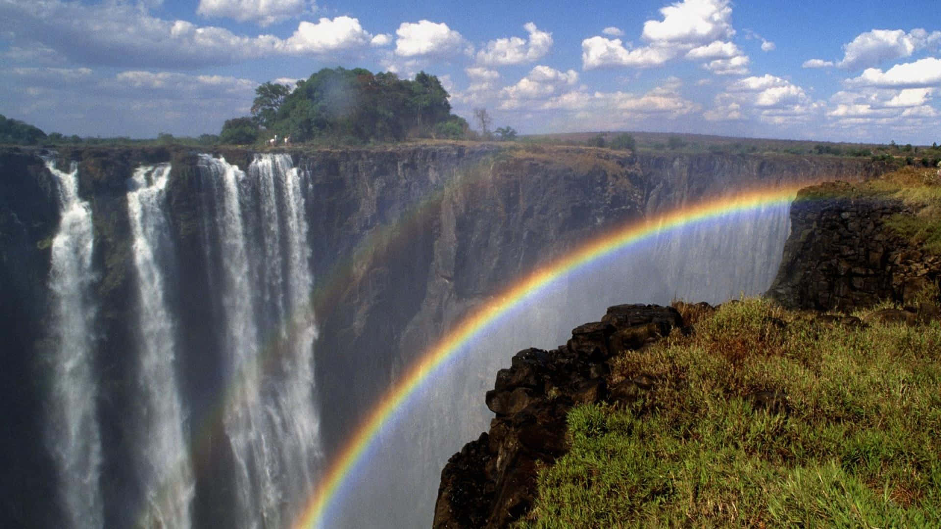 Victoria Falls With A Half Rainbow Background