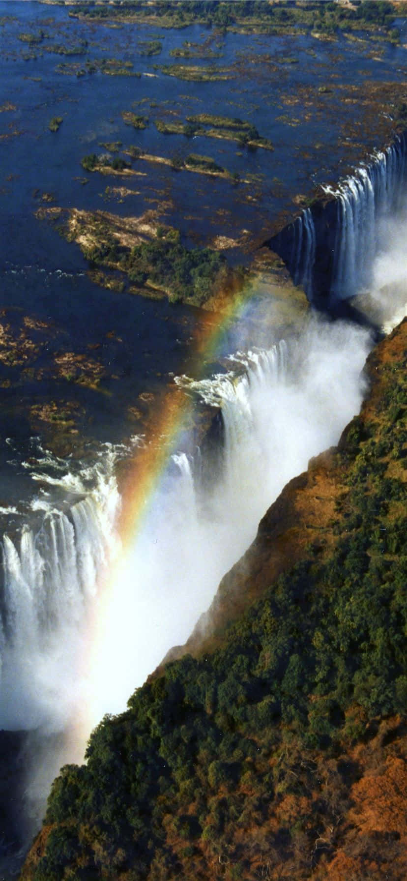 Victoria Falls With A Rainbow Background