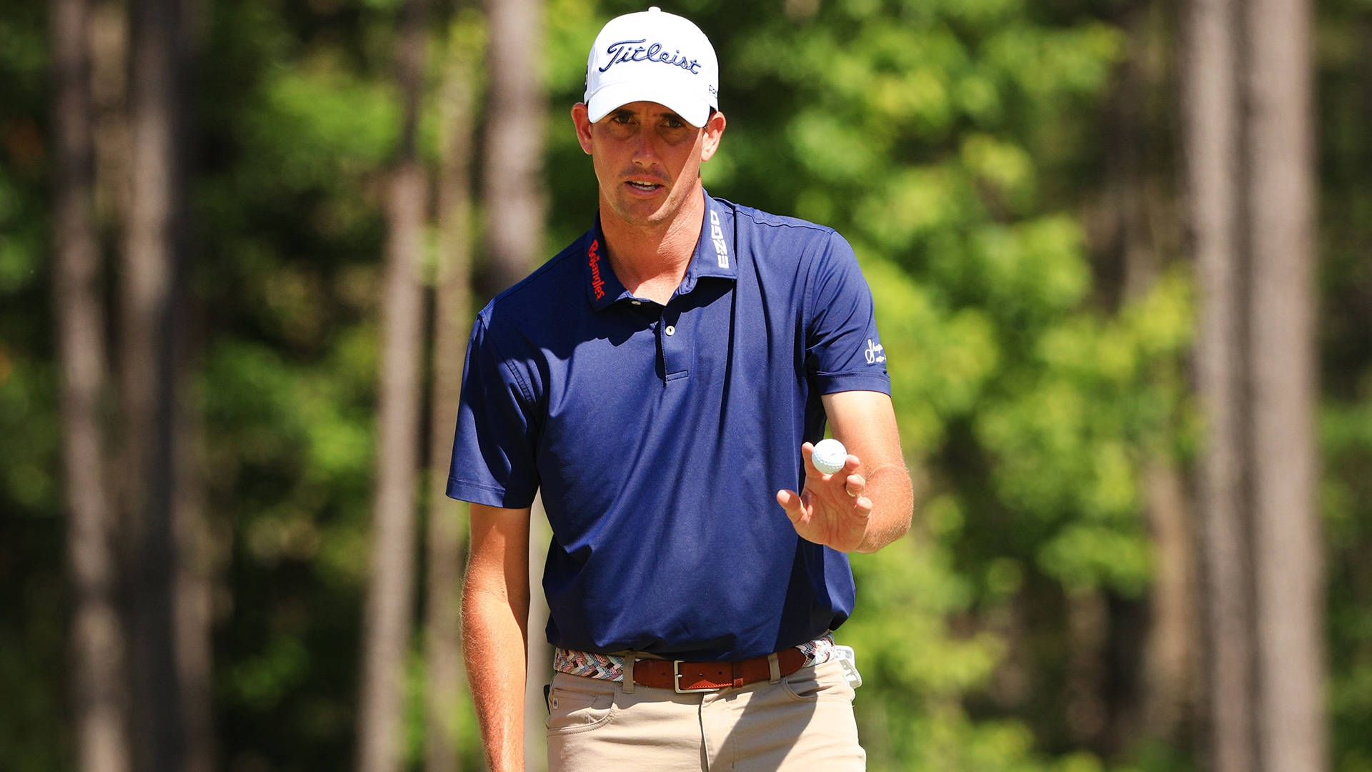 Victorious Chesson Hadley Proudly Holding Up A Golf Ball Background