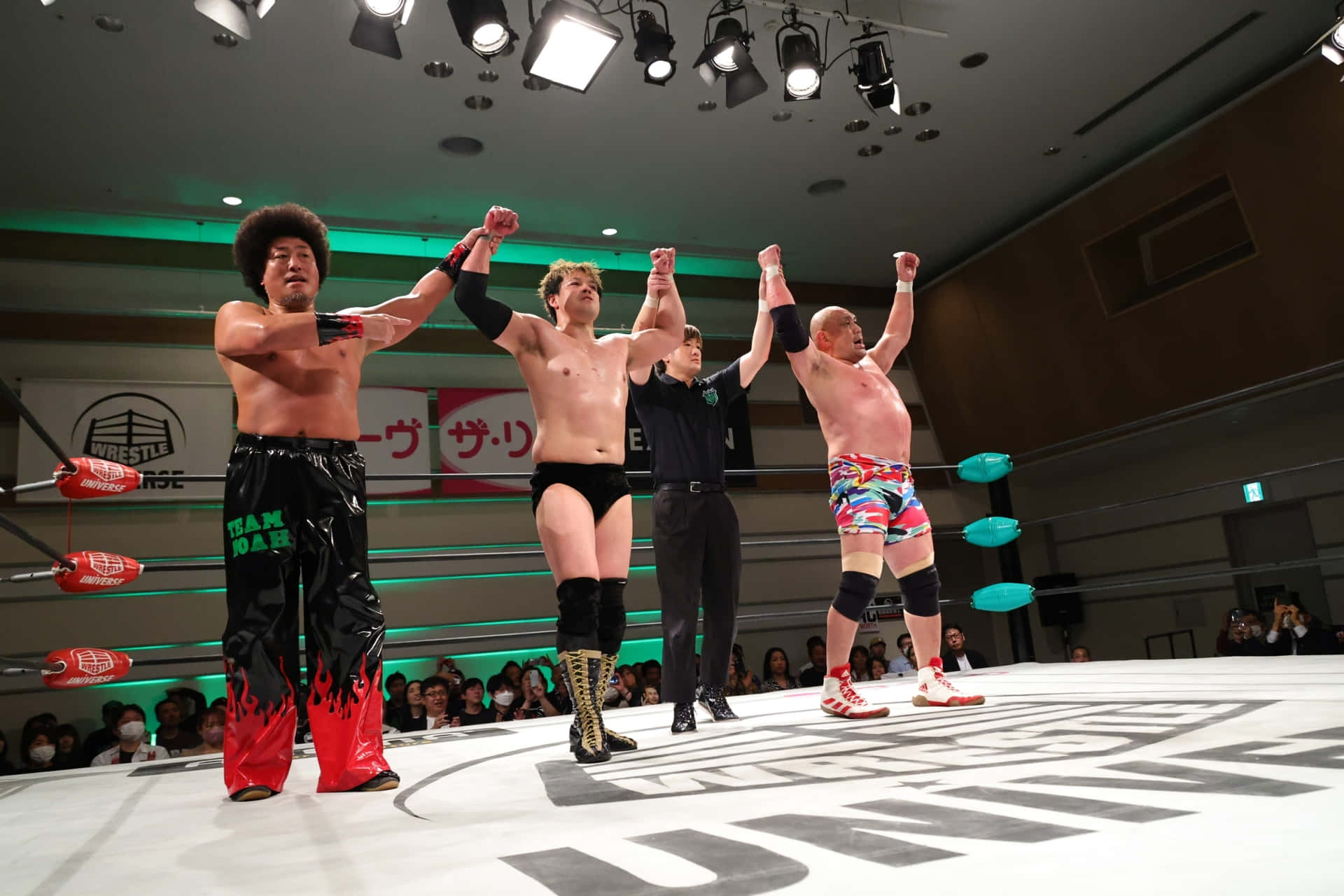Victorious Wrestlers Celebrating In Ring Background