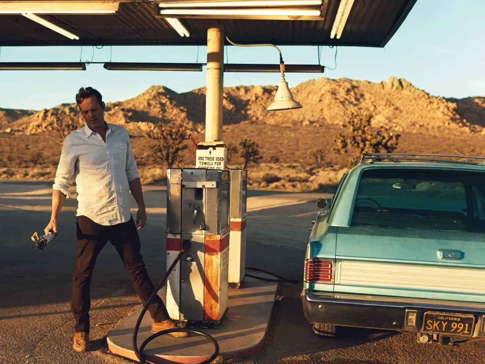 Vince Vaughn Charmingly Posing Against A Dark Background Background