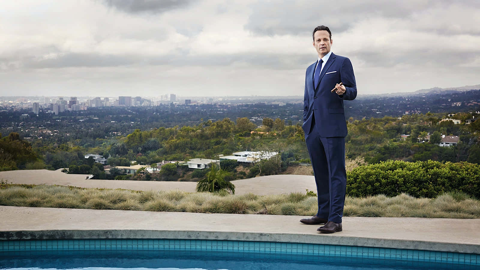 Vince Vaughn Posing In A Stylish Outfit Against A Captivating Backdrop Background