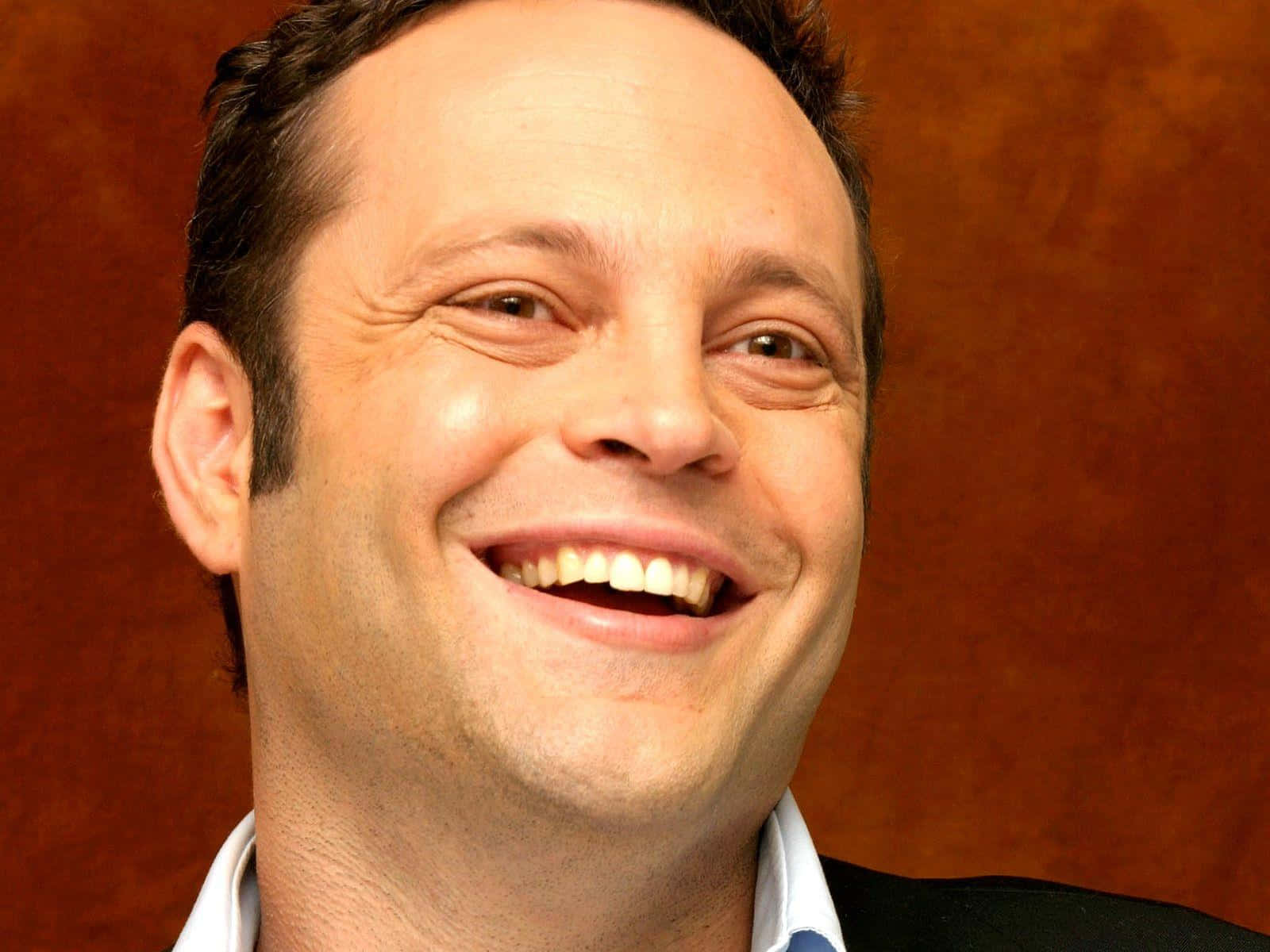 Vince Vaughn Smiling In A Suit Background
