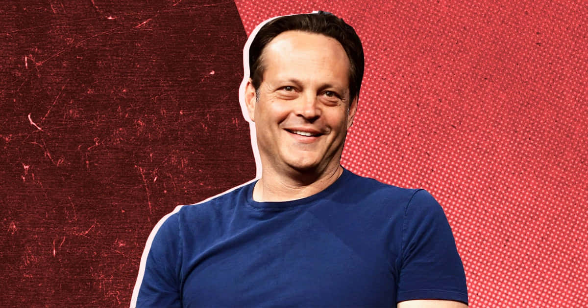 Vince Vaughn Striking A Confident Pose Against A Blue Backdrop Background