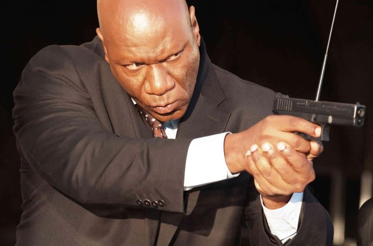 Ving Rhames Posing In A Black Suit And Tie. Background