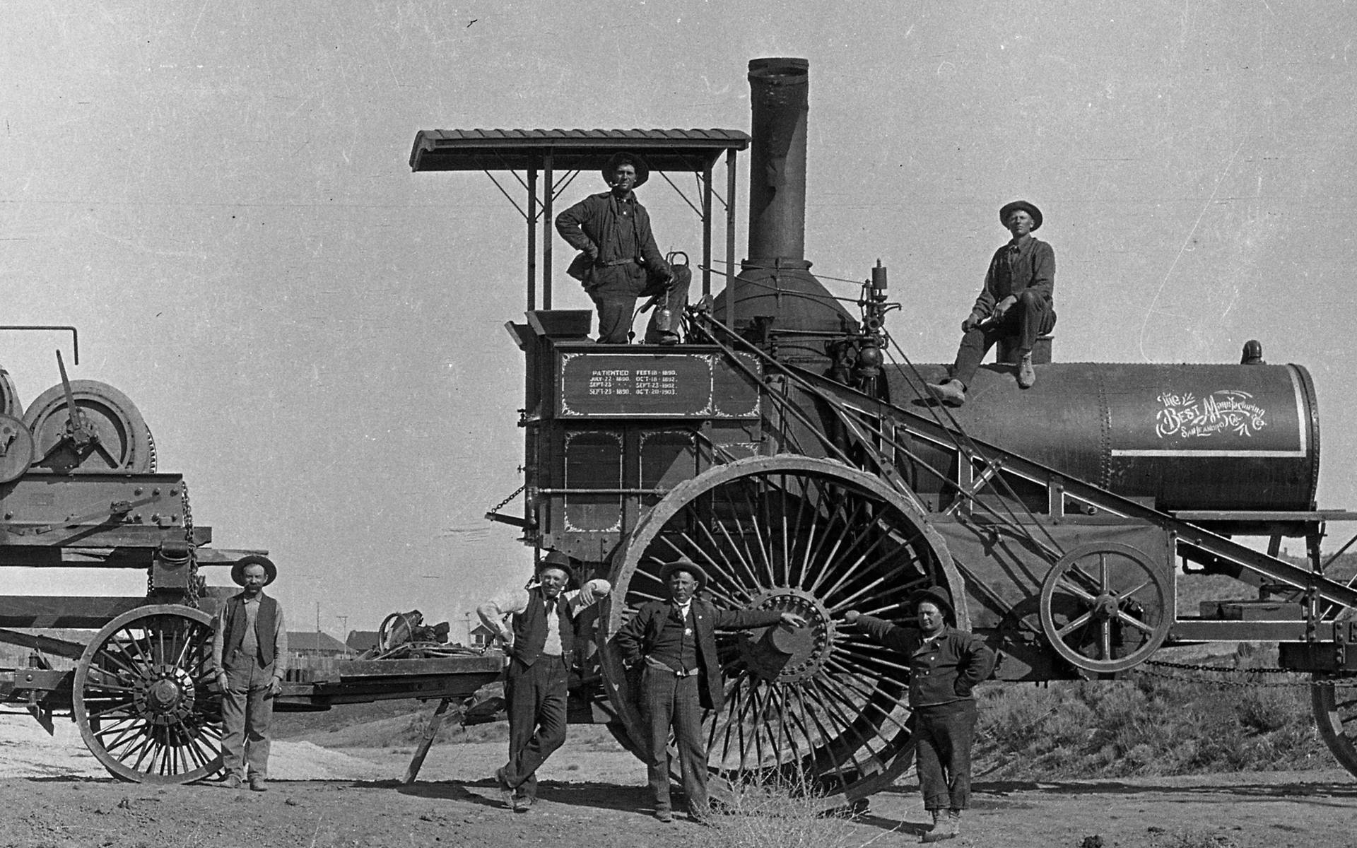 Vintage Black And White Photo Of People With Steam Tractor Background