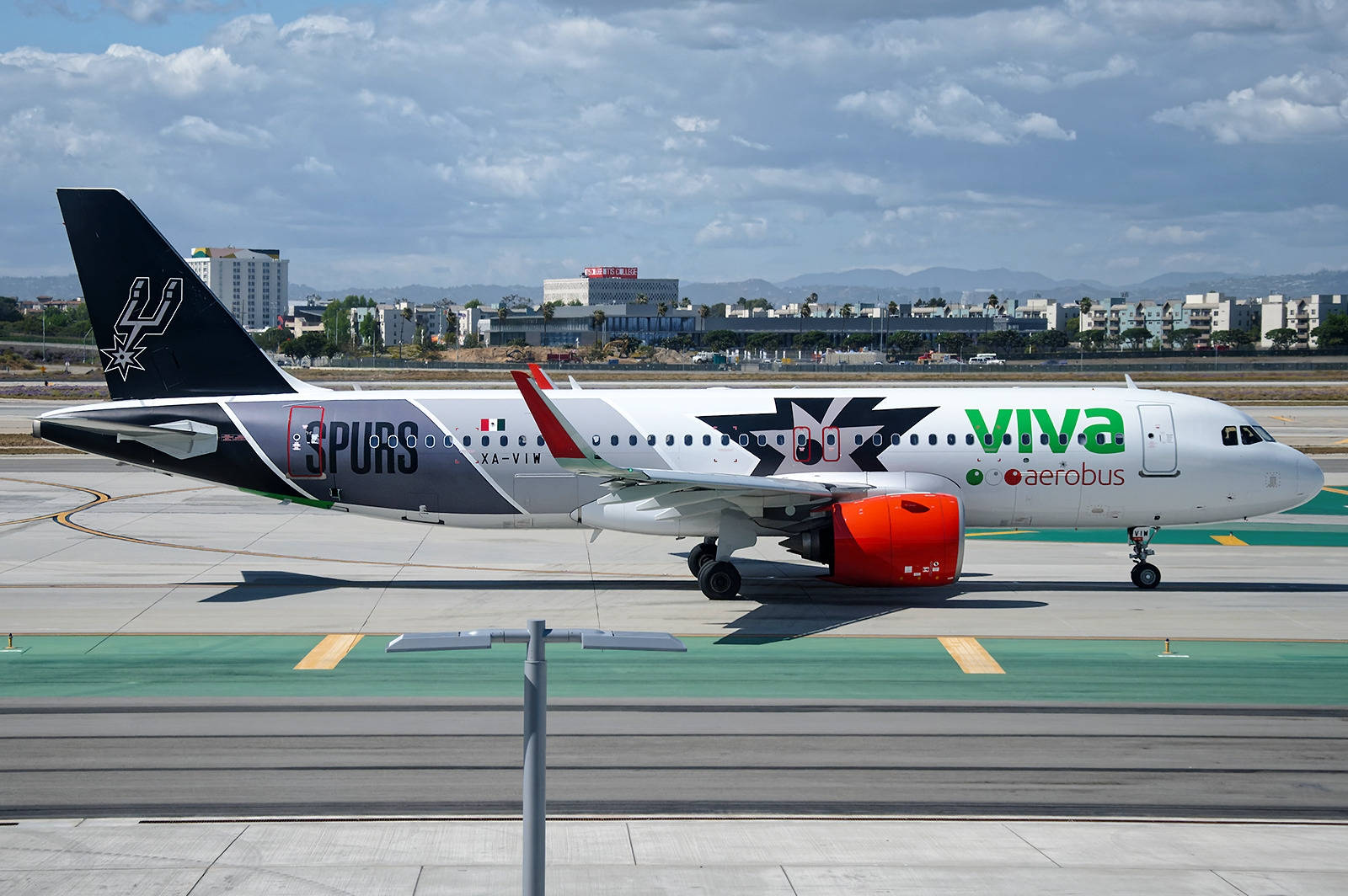 Viva Aerobus Side View With City Background Background