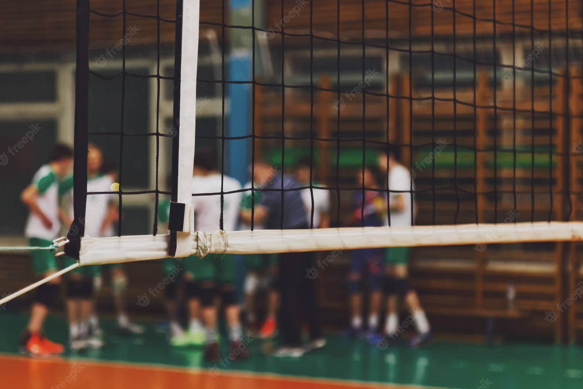 Volleyball Net In A Gym With People Playing Volleyball Background