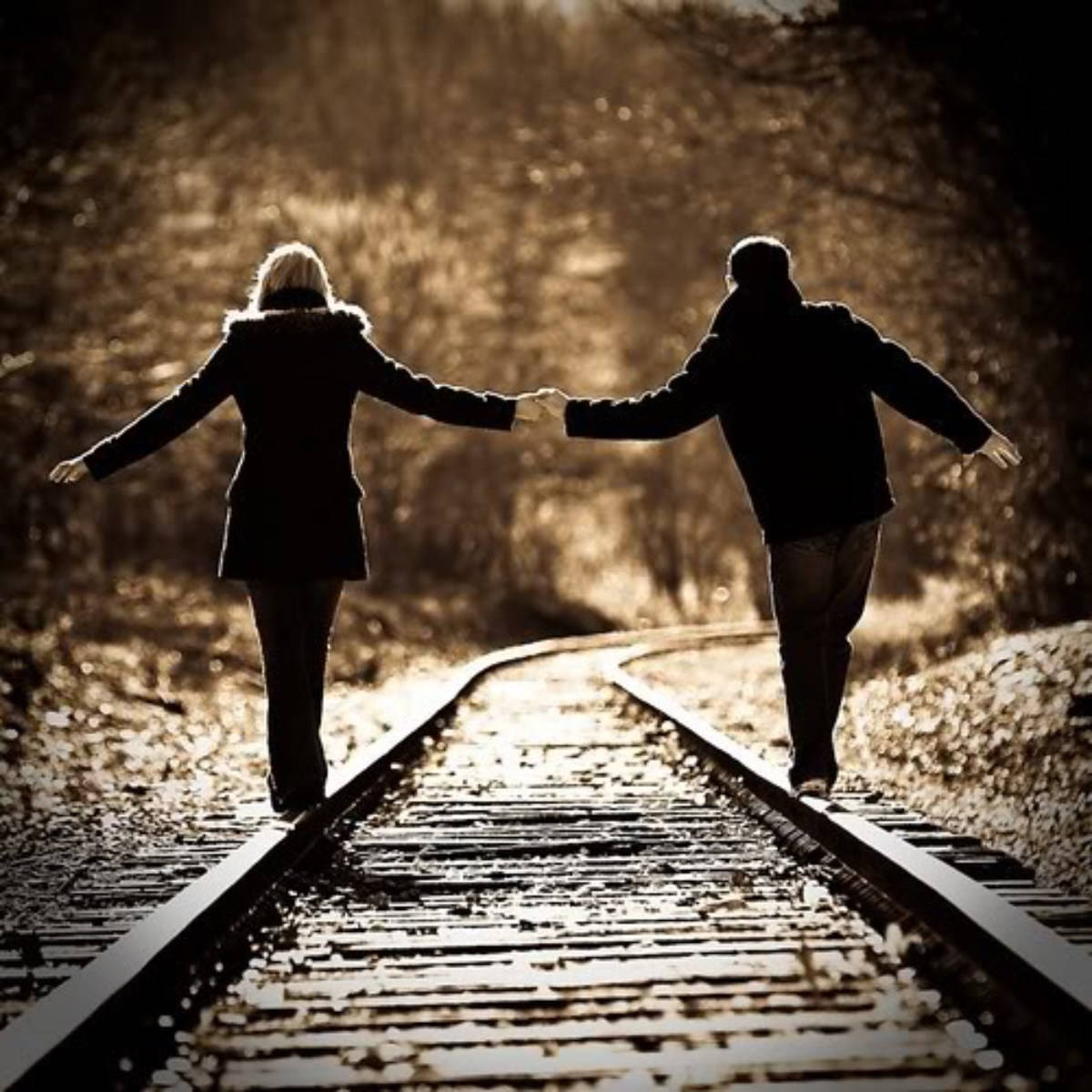 Walking Hand In Hand On A Railway Line