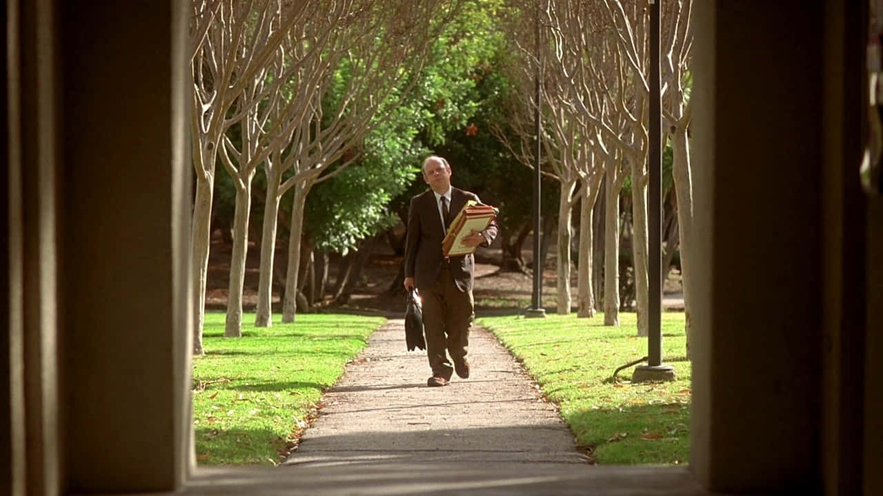 Wallace Shawn Relaxing In A Chair Background