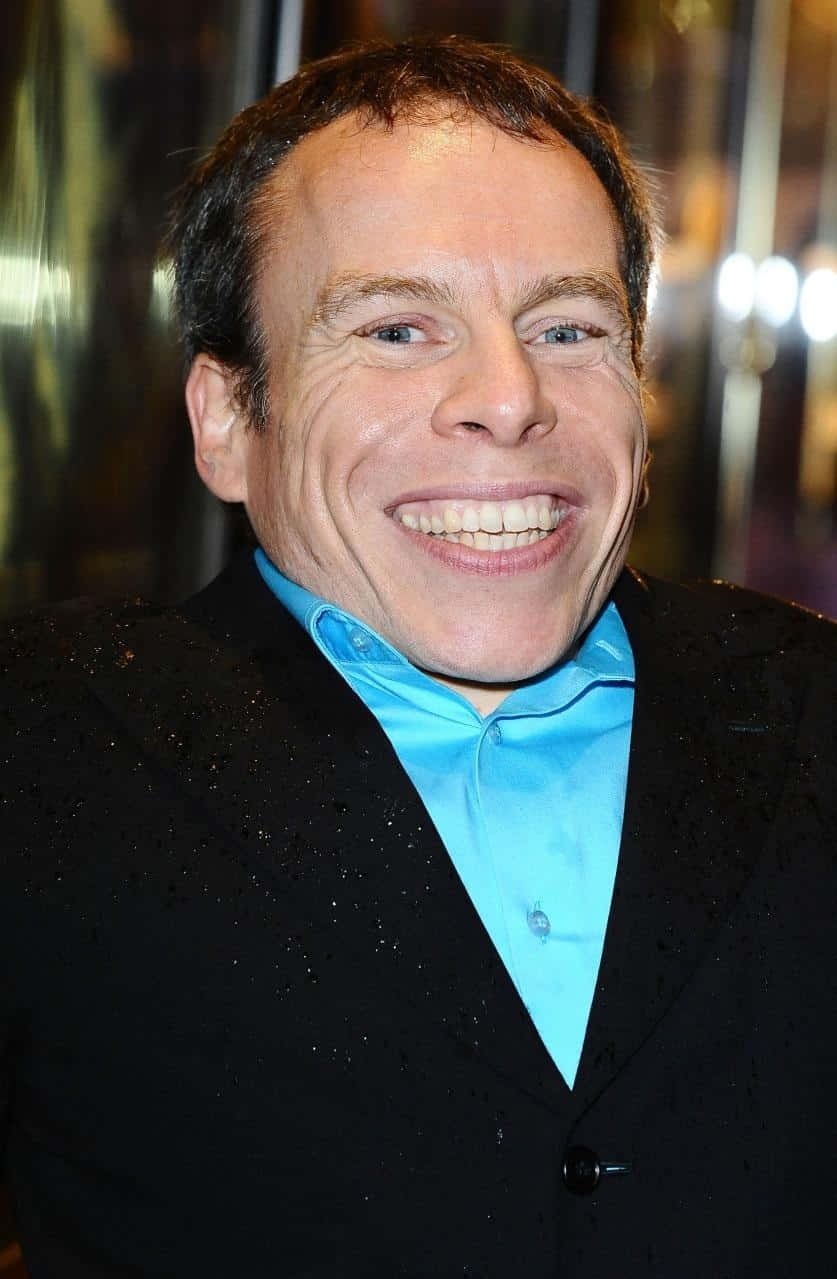 Warwick Davis Poses In A Stylish Photo Shoot Background