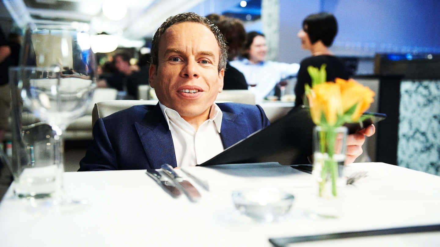Warwick Davis Smiling And Posing For The Camera Background