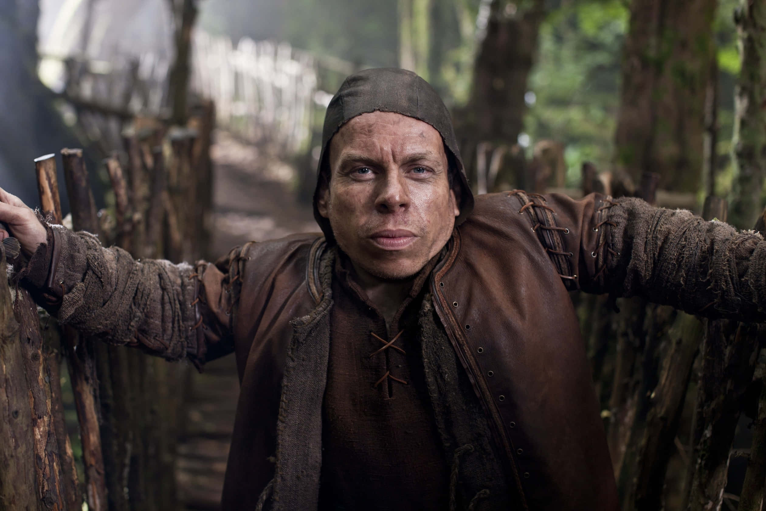 Warwick Davis Strikes A Pose In A Relaxed Photoshoot Background