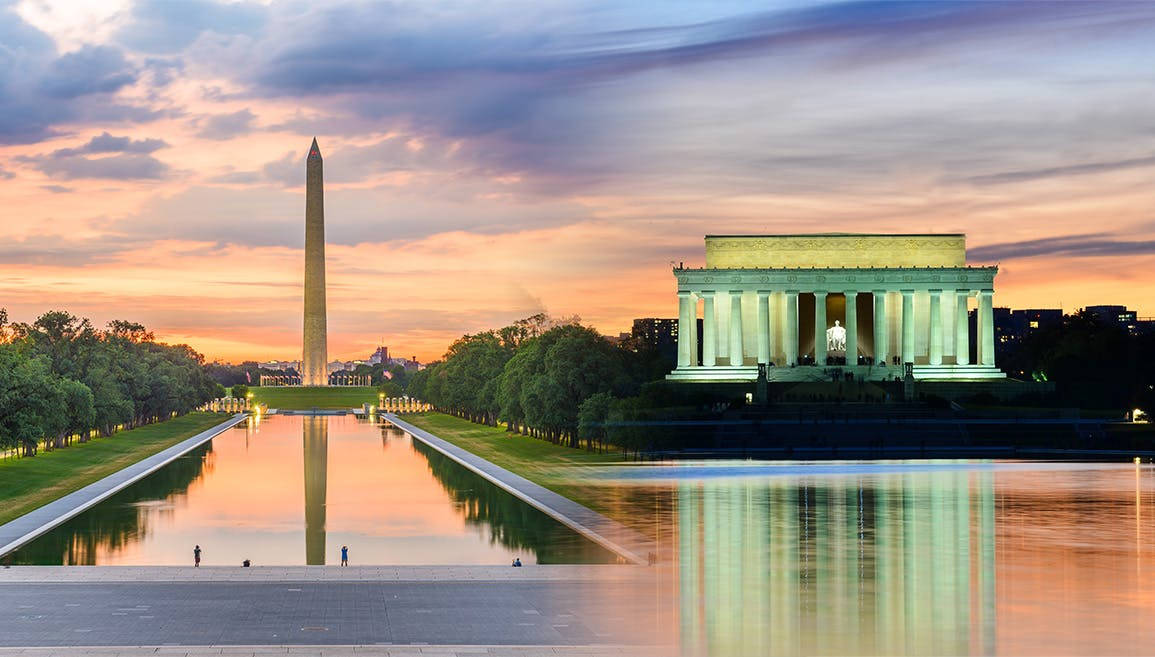 Washington Monument By The Lincoln Memorial Under Clear Blue Sky Background