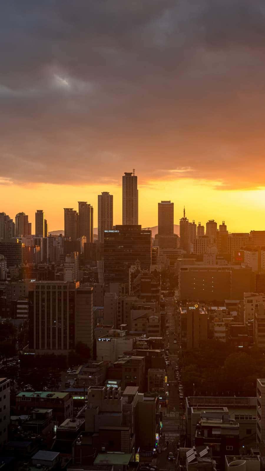 Watching A Beautiful Sunset Over A Vibrant City Skyline Background