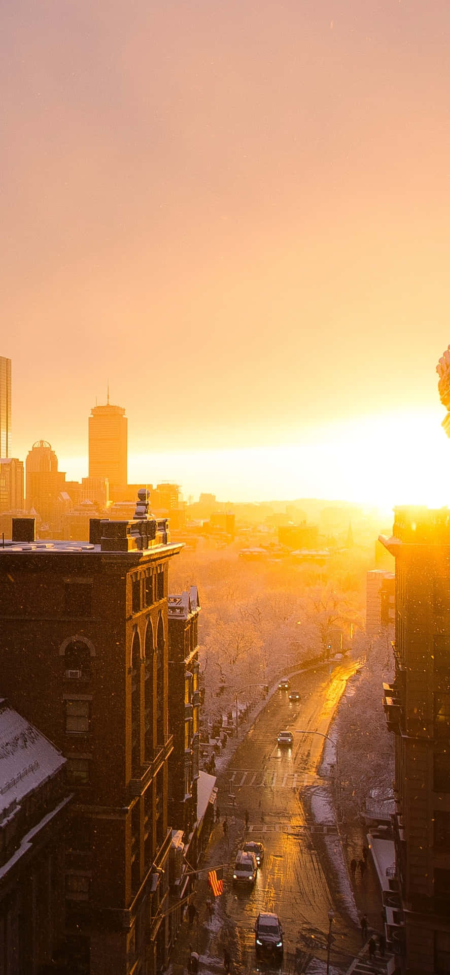 Watching The Orange Glow Of The Sunset Over The City Skyline Background