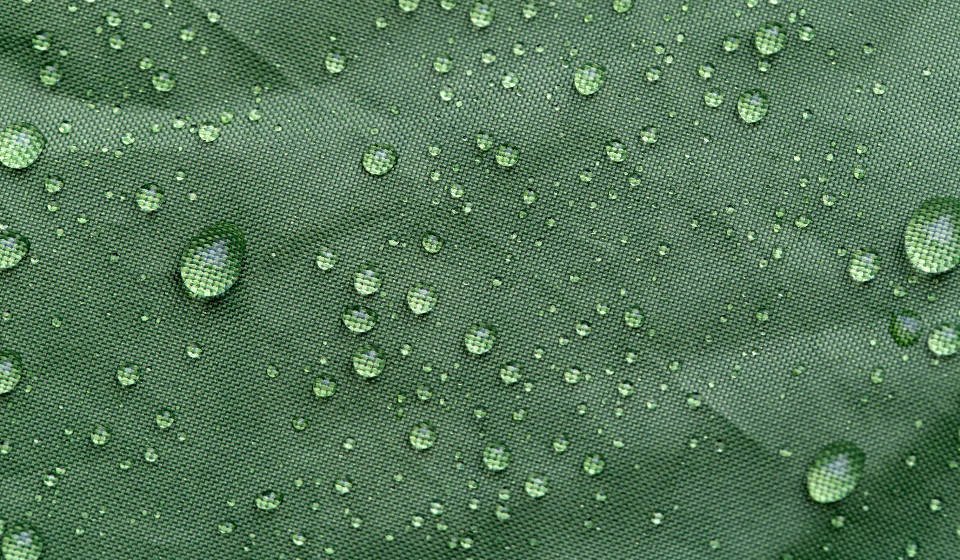 Water Droplets On Green Fabric Background